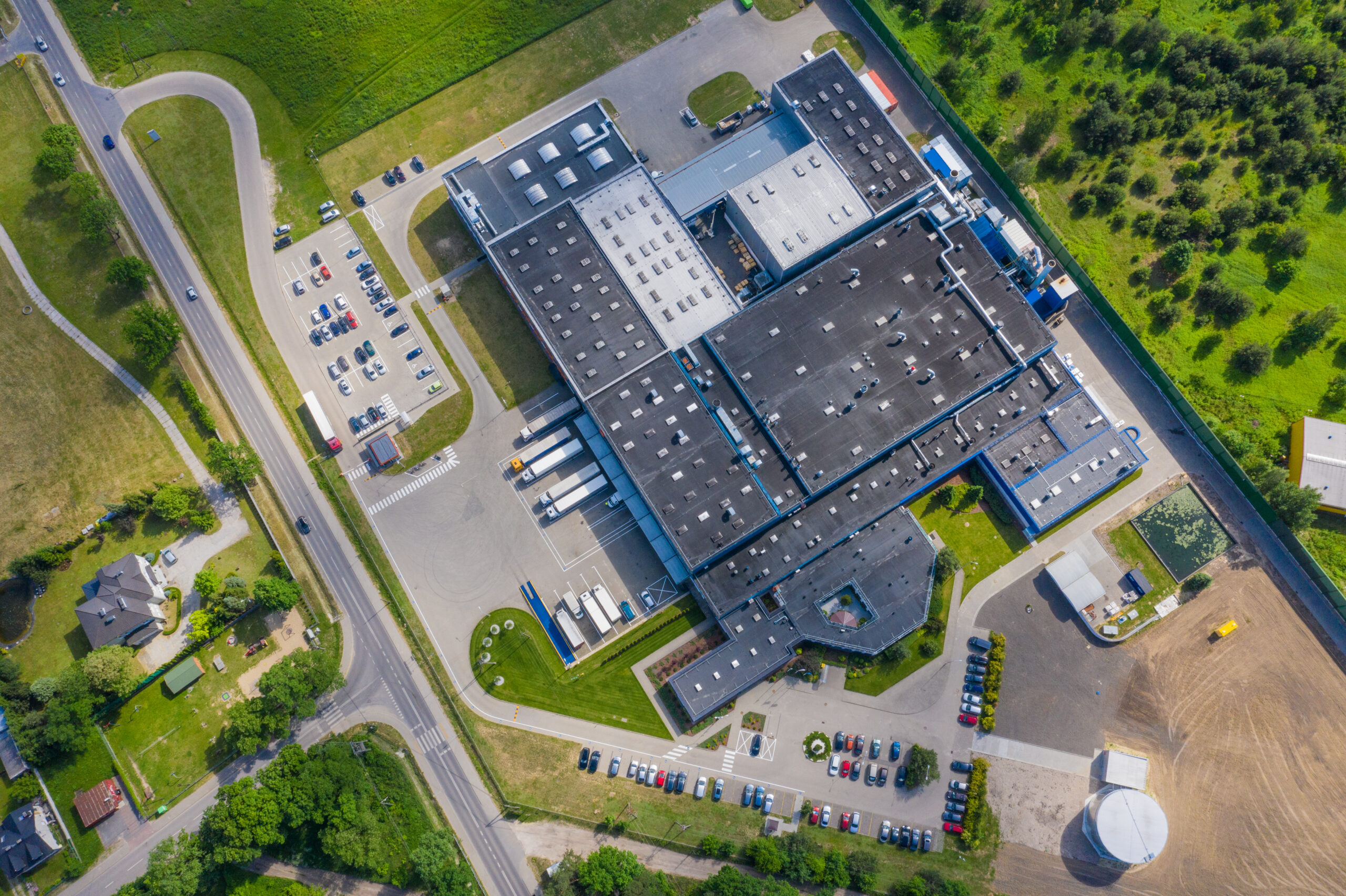 Aerial view of goods warehouse. Logistics center in industrial city zone from above. Aerial view of trucks loading at logistic center